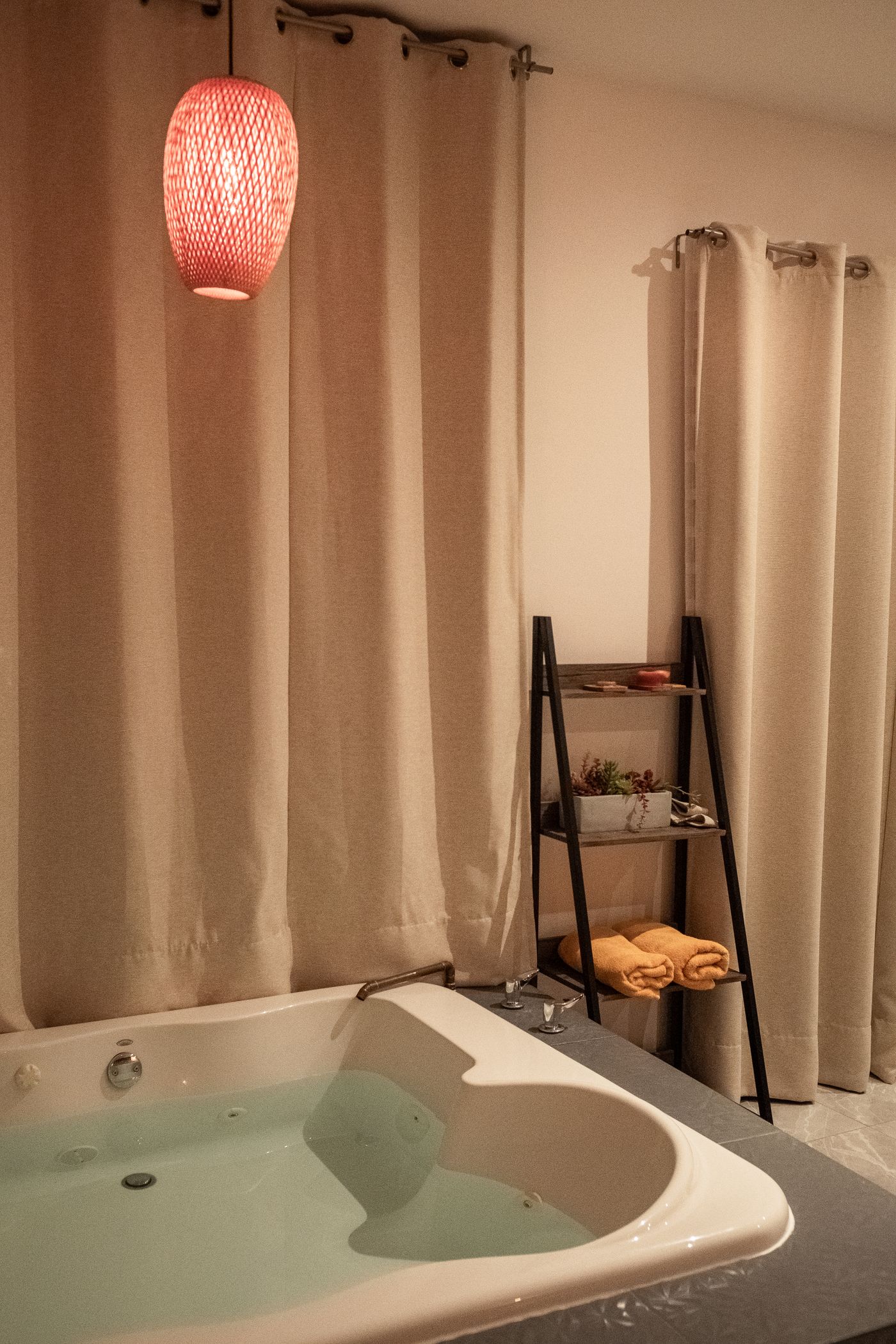 Interior del estudio: cortinas en tonos cálidos y repisa con productos